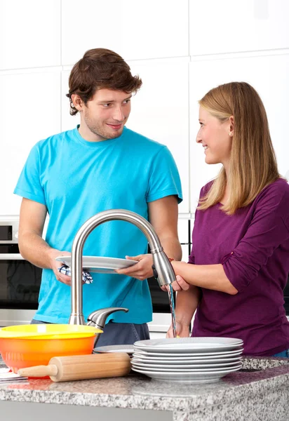 Young man helping his wife in household