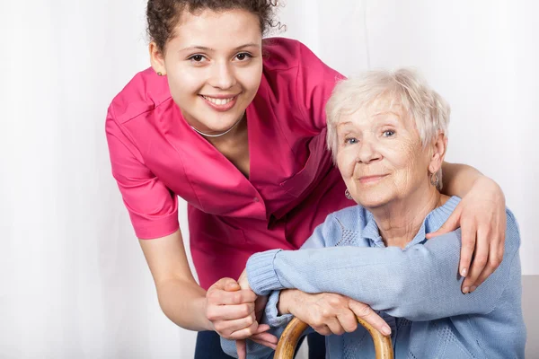Nurse with sitting elderly woman