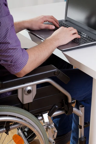 Man on wheelchair working on laptop