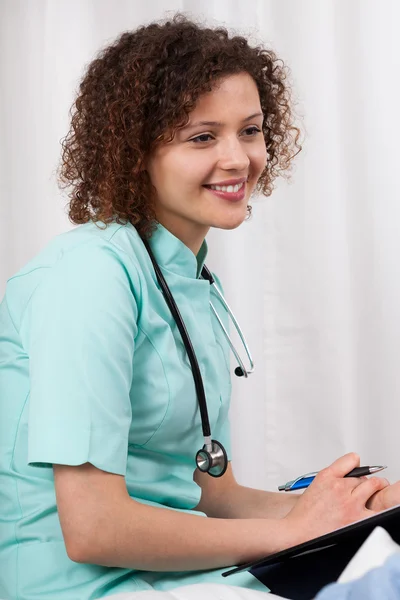 Nurse with stethoscope takes notes