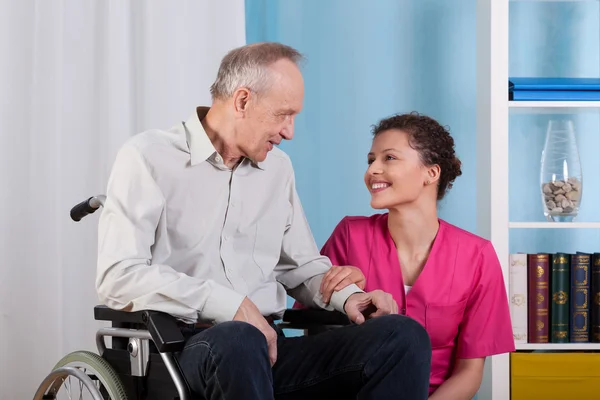 Nurse smiles to sitting patient