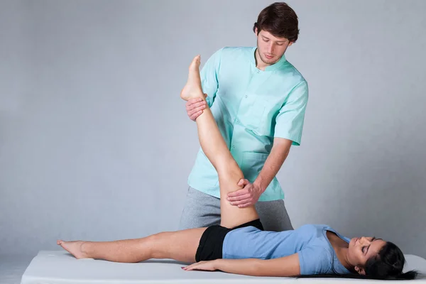 Physiotherapist stretching patient