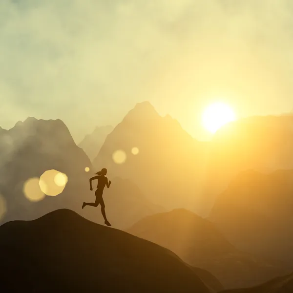 Silhouette of a beautiful woman running down the hill against yellow sky with clouds at sunset