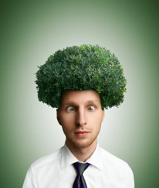 Young cross-eyed man with green bush