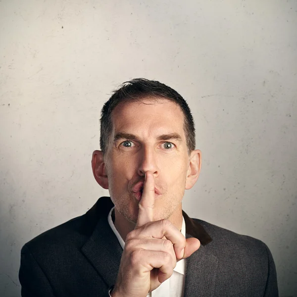 Man showing silence gesture with his finger over mouth