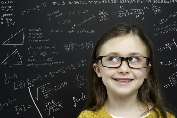 Smart young girl stood infront of a blackboard