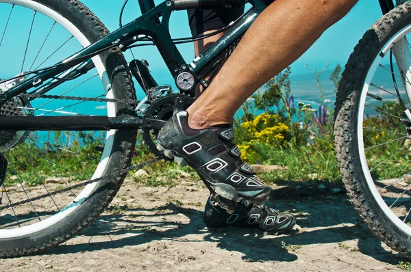 The rider\'s foot on a pedal bike