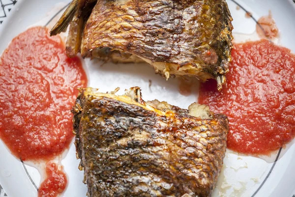 Baked tilapia served with red pepper sauce
