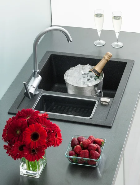 Granite kitchen sink with mixer tap, red flowers and strawberrie