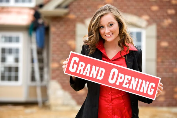 Construction: Woman Holds Up Grand Opening Sign