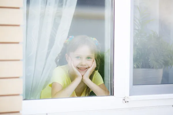 Smiling girl looks in a window