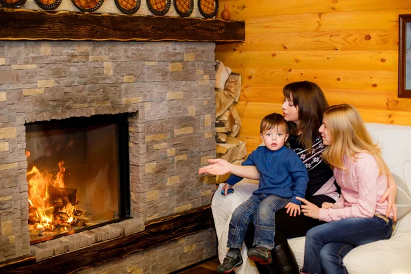 Mom with her daughter and son sitting near the fireplace