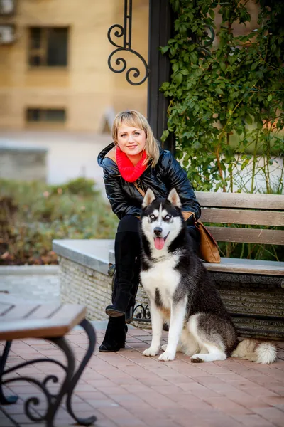 Woman and dog sitting on bench