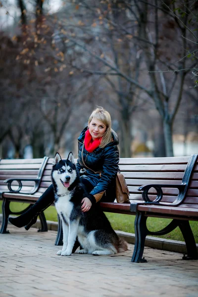 Woman and dog sitting on bench