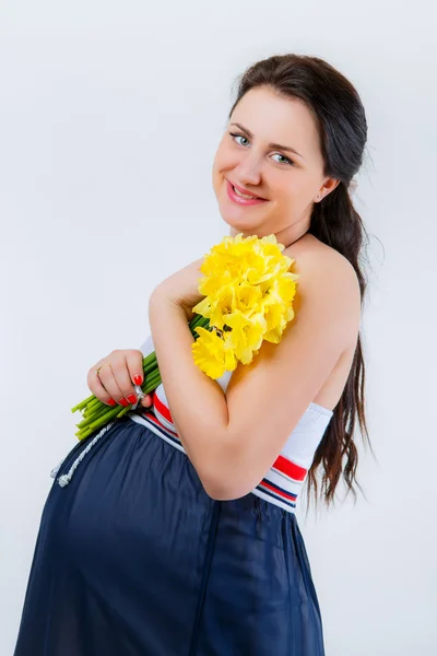 Pregnant girl with a bouquet of narcissus