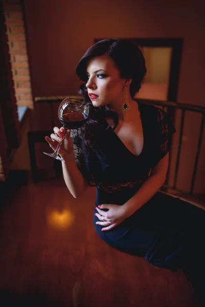 Girl in the  evening dress drinking wine