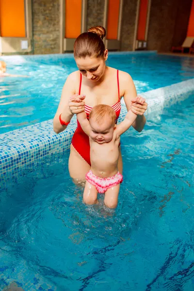 Mother with a child is engaged in the pool.