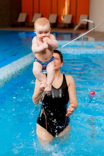 Coach engage with the child in the pool.