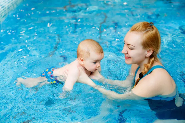 Happy mother with her son in the pool.