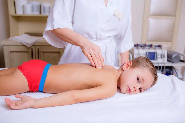 Doctor massaging little boy