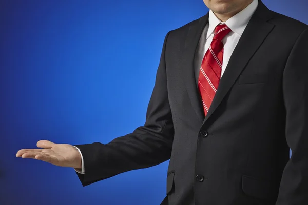 Businessman in a black suit shows an empty hand — Stock Photo #30339465