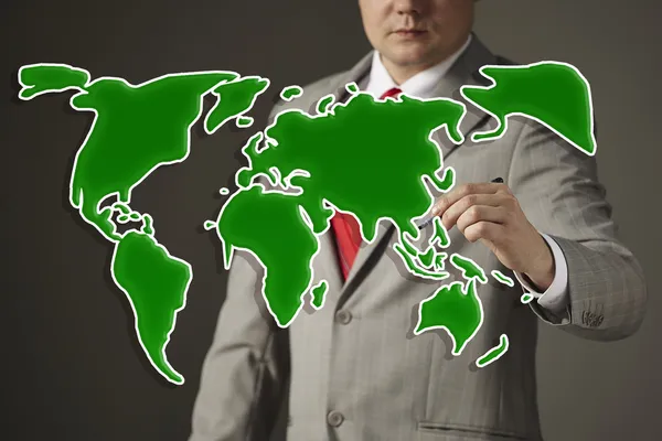 Businessman drawing a green world map