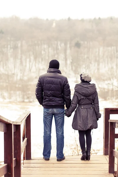 Couple in winter park on the bridge