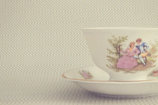 Vintage tea cup over background with zigzags