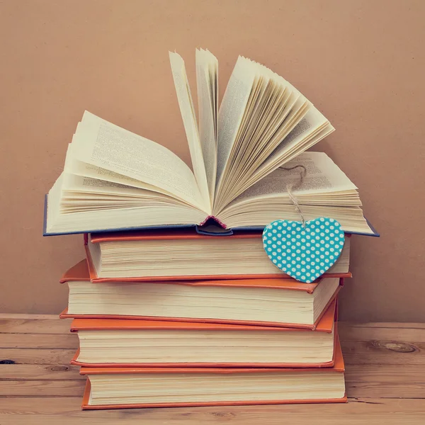 Books on wooden table with heart shape
