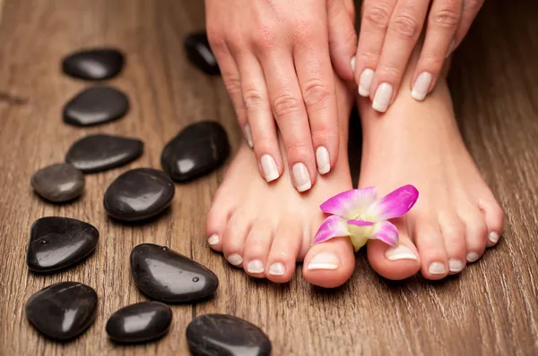 Relaxing pink manicure and pedicure with a orchid flower