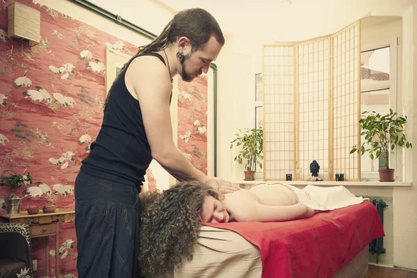 Young woman on massage table getting healing bodywork massage