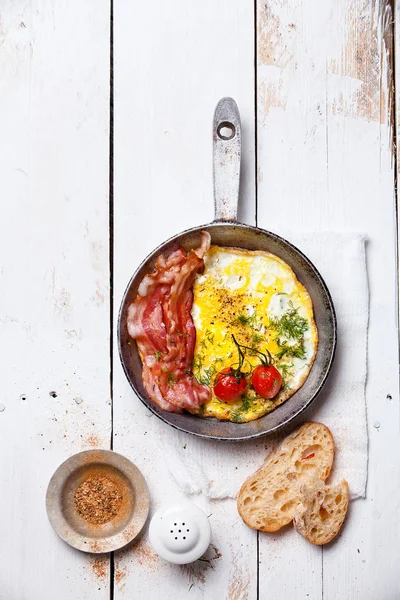 Breakfast with Fried eggs and bacon on pan