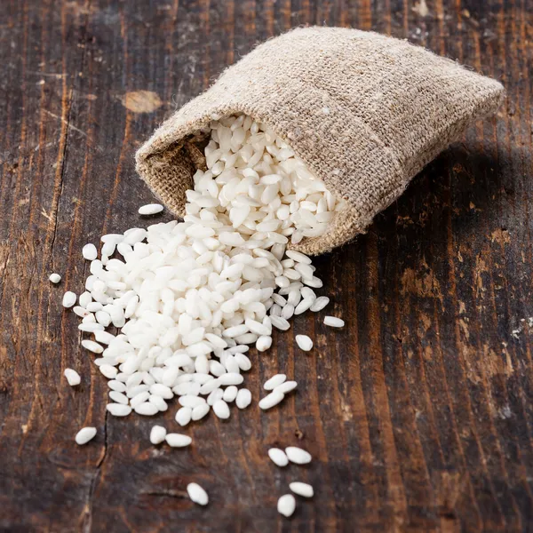 Raw white rice in burlap bag