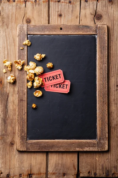 Slate chalk board with popcorn and two movie tickets on