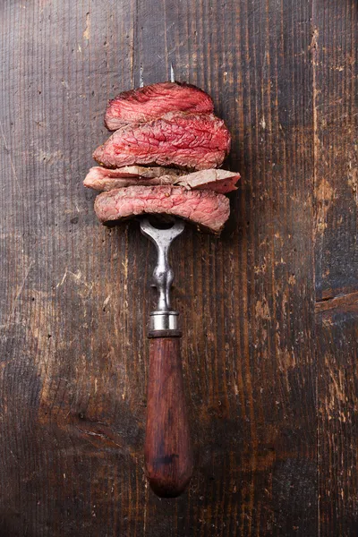 Slices of beef steak on fork