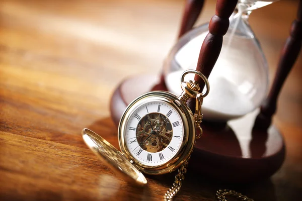 Gold pocket watch and hourglass