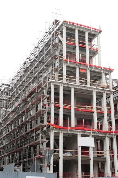 High rise construction site with a concrete structure in the process of being built as a commercial real estate structure and a business symbol of economic and financial growth and healthy economy.