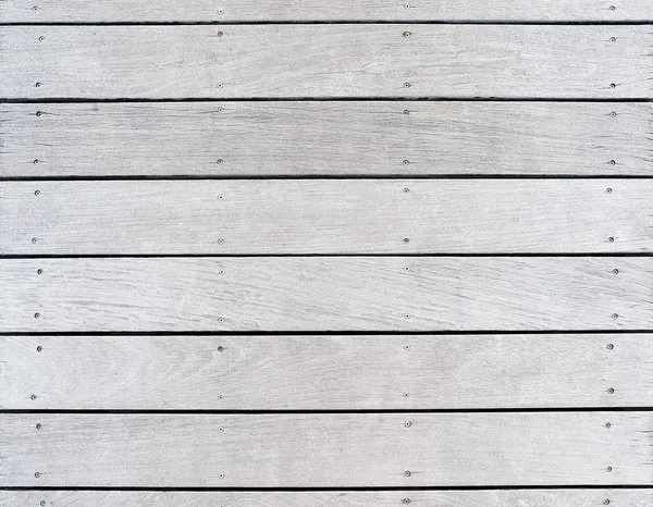A boat dock\'s old weathered and faded wood decking.