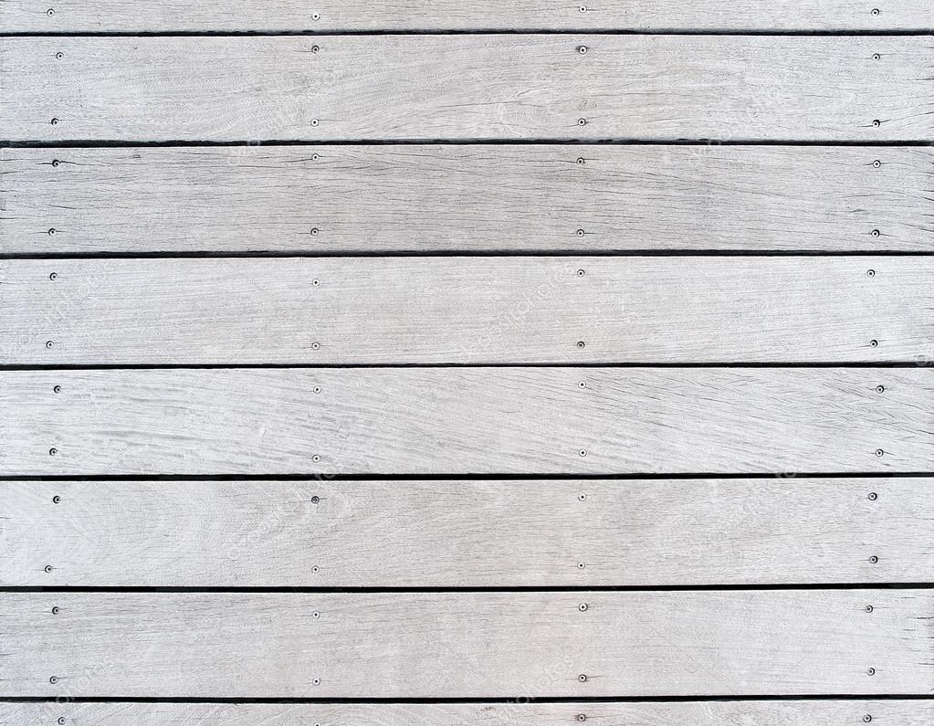 A boat dock's old weathered and faded wood decking ...