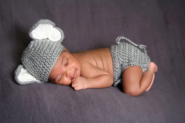 Newborn baby boy wearing a gray crocheted elephant hat and diaper cover.