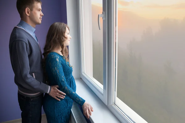 The couple is looking out the window