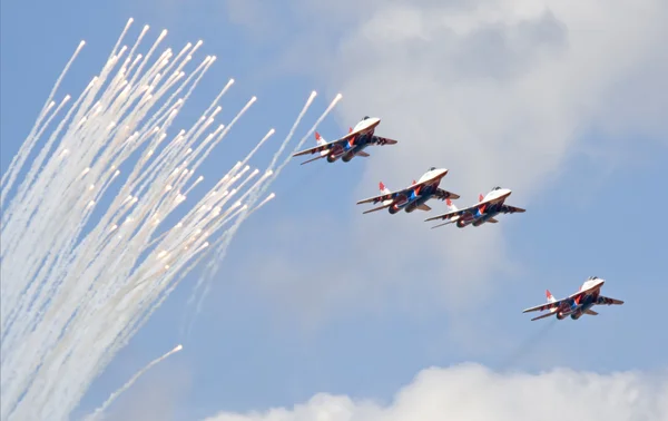 MiG-29 jets from Strizhi fighters performing aerobatic elements and ejecting thermal traps (salute)