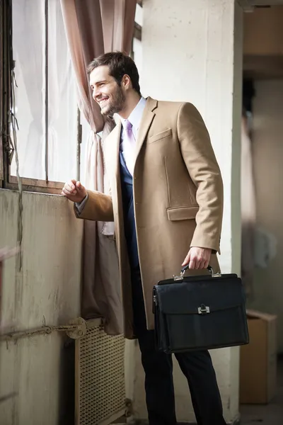 Young and handsome businessman looking out of the window