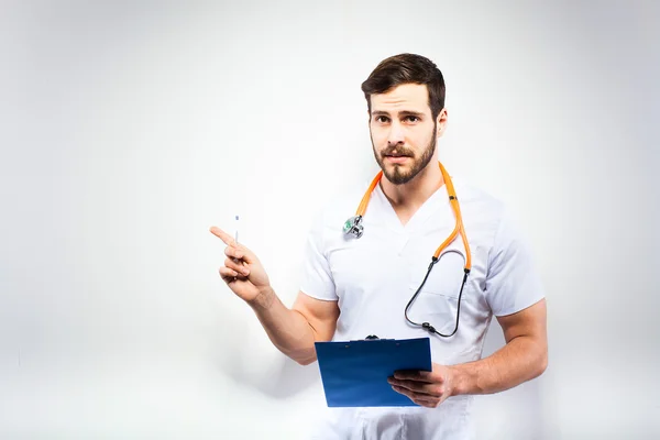 Handsome doctor standing next to wall