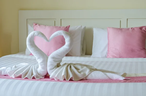 Bed decoration with pink pillows and swan towel