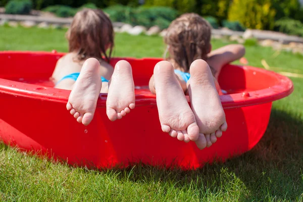 Close-up of feet two sisters in small pool