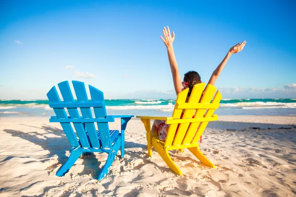 Young woman in beach chair raised her hands up