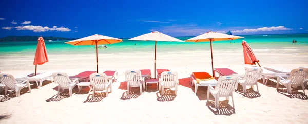 Beach chairs in exotic resort on perfect white sandy beach
