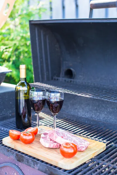 Fresh meat, vegetables and bottle of wine on a picnic outdoors