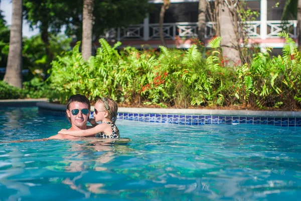 Adorable little girl have fun with father in the pool